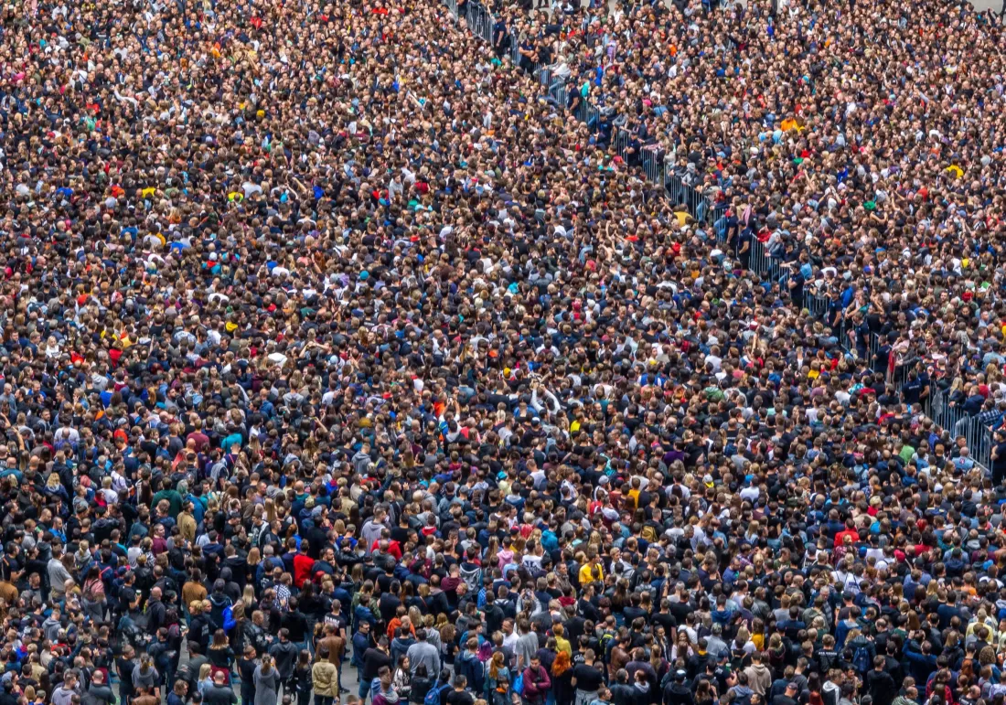 Grosse Menschenmenge, durch Barriere geteilt. (Adobe Stock)